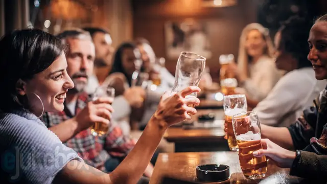 Good music in your pub can increase sales - friends raising beers in a busy pub with eJukebox music