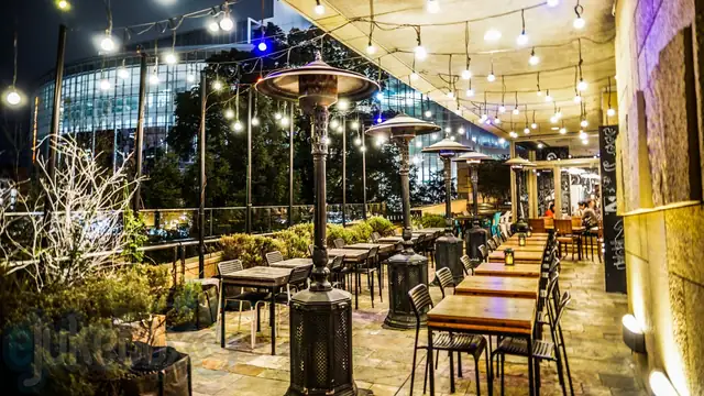 Music creates atmosphere - an outdoor dining terrace under festoon lights, set for eJukebox background music