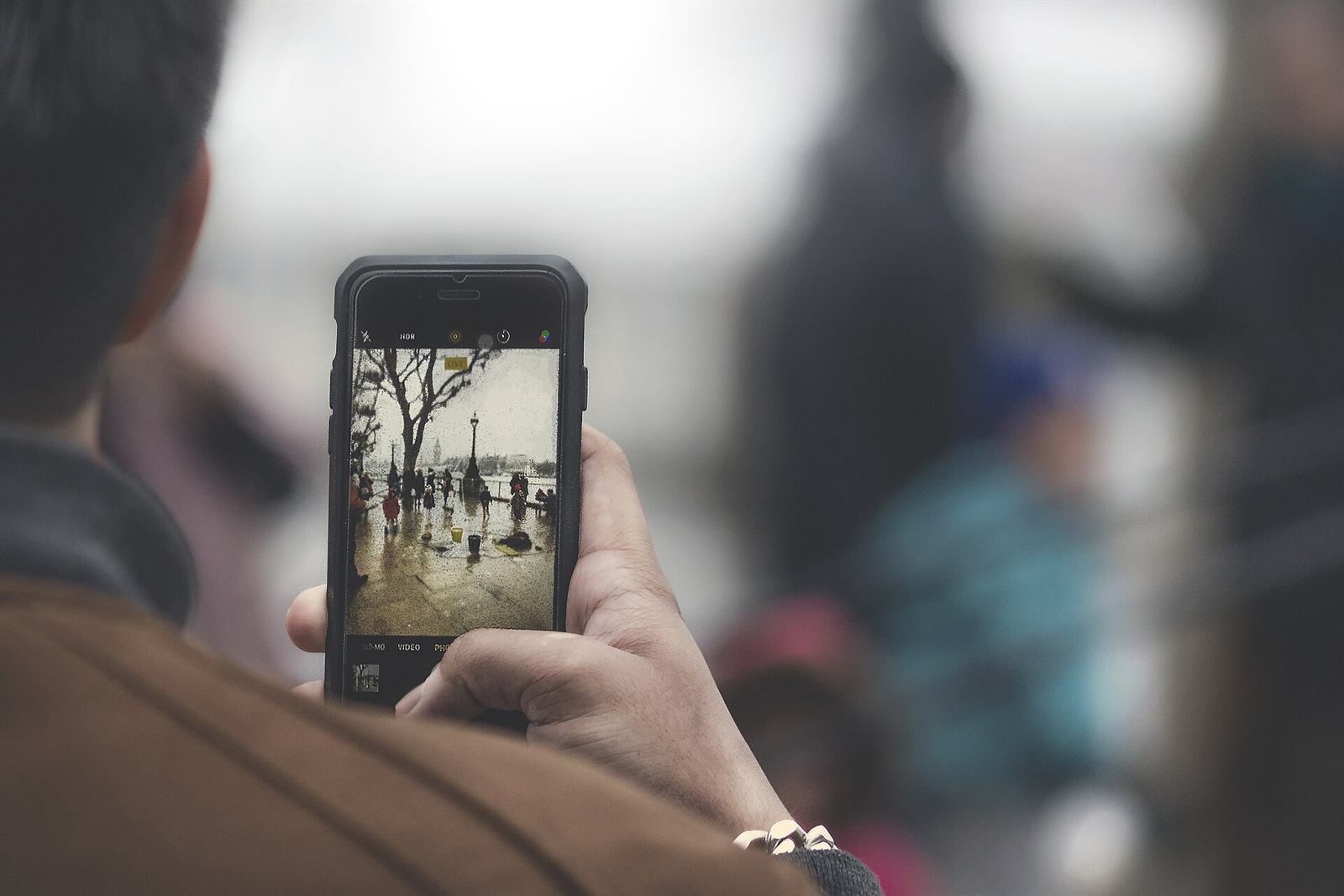 A phone held up in a crowded, glowing room