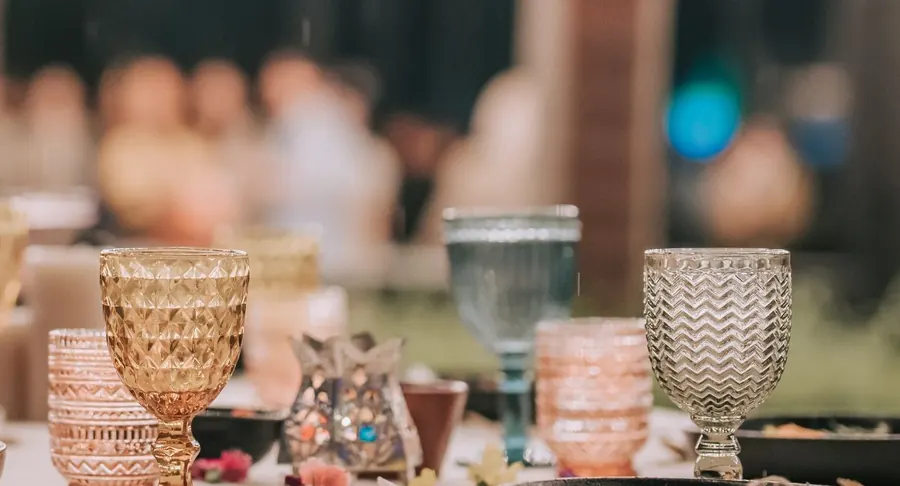 A function table set with coloured glassware under fairy lights