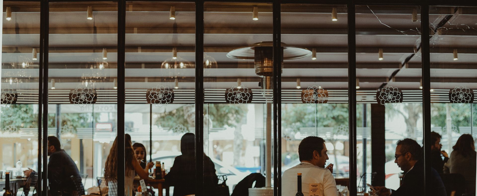 Diners at tables in a glass-walled club bistro